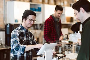 Cashier attending to customer in cafe