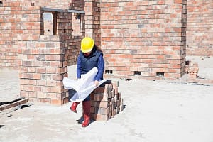Site manager looking at blueprint on construction site